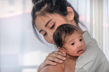 güzel Asyalı anne onu sevimli bebek bebek erkek bebek tutan onu s