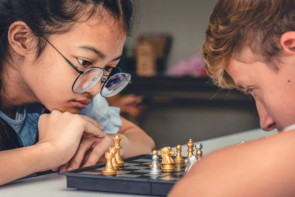 birlikte satranç tahtası oynayan gençler