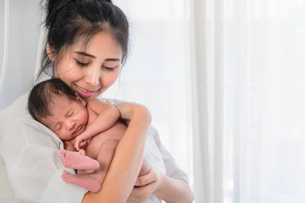 Asyalı anne mutluluk la elinde onun bebek erkek tutan