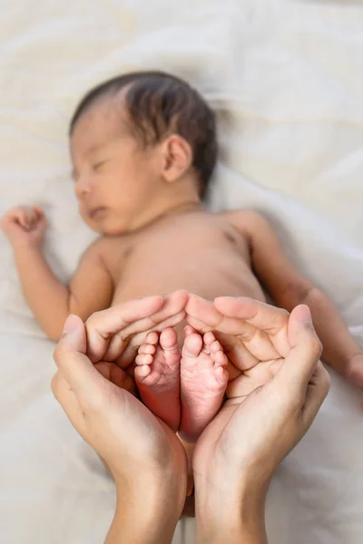 Onun bebek bebek erkek ayakları tutarak anne elleri yakın — Stok fotoğraf