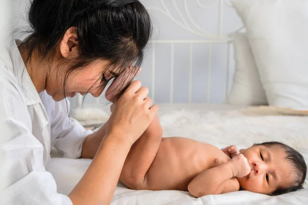 Asyalı anne elinde onu bebek bebek erkek ayakları tutarak — Stok fotoğraf