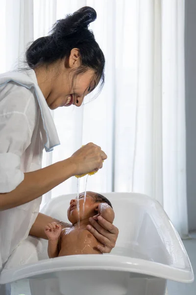 Asiática madre bañando su bebé — Foto de Stock