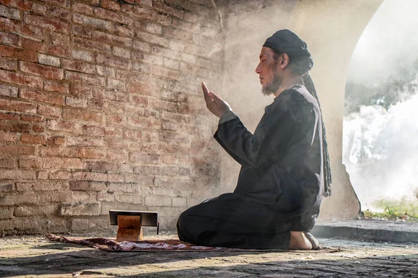Viejo musulmán macho orando con corán en antigua mezquita —  Fotos de Stock