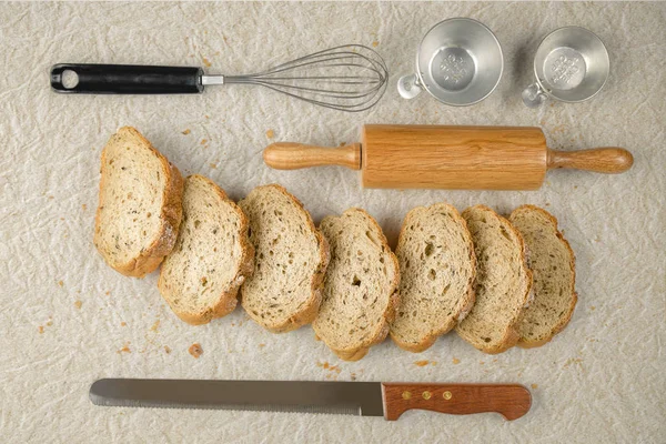 Харчовий фон з нарізаного хліба з хлібопекарськими інструментами на паперовому фоні — стокове фото