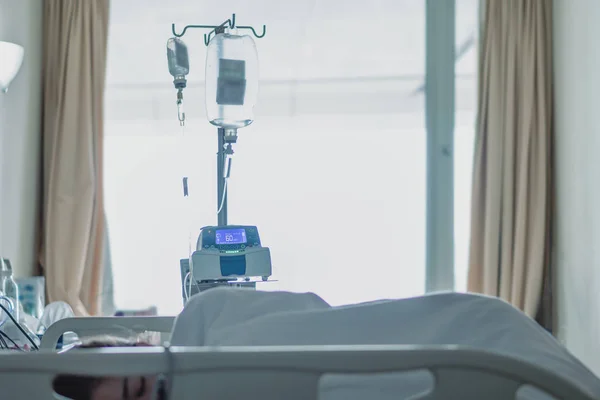 Saltlösning enhet med en kvinnlig patient på sängen i sjukhuset återhämtning PA — Stockfoto