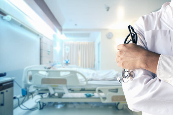 hand of doctor holding stethoscope with blurred background of re