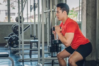 spor salonunda erkek kaldırma dumsbells