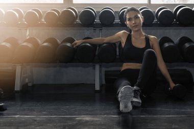 female relaxing after work out in gym