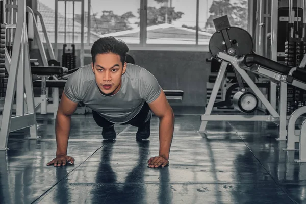 Masculino tendo exercício empurrando para cima no ginásio — Fotografia de Stock