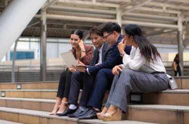 asya iş adamları grubu kucak ile açık havada oturan
