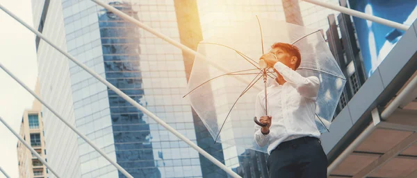 Asiático negocio ejecutivo con unbrella beber café al aire libre —  Fotos de Stock