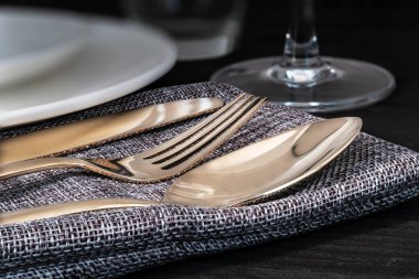 Bronz çatal bıçak, kaşık, çatal ve bıçak bir dizi peçete üzerinde düzenlemek