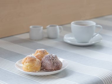 bir afternoo için bir fincan çay veya kahve ile chou krem bir tabak