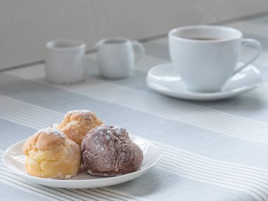 bir afternoo için bir fincan çay veya kahve ile chou krem bir tabak