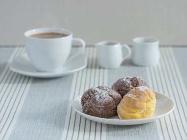 bir afternoo için bir fincan çay veya kahve ile chou krem bir tabak