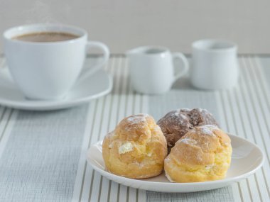 bir afternoo için bir fincan çay veya kahve ile chou krem bir tabak