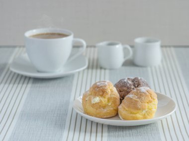 bir afternoo için bir fincan çay veya kahve ile chou krem bir tabak