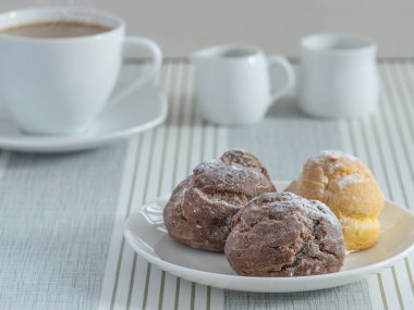 bir afternoo için bir fincan çay veya kahve ile chou krem bir tabak