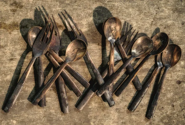 Lavoro in processo di posate di bronzo di cucchiai e forchette su legno — Foto Stock