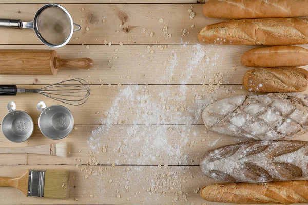 Різноманітні види хліба на дерев'яному столі з різноманітністю випічки — стокове фото