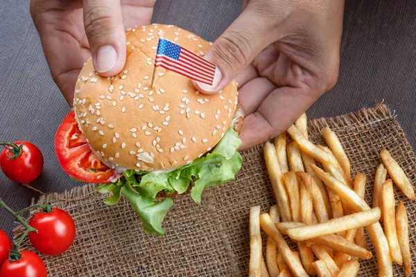 Amerikan bayrağı ile Hamburgerler fr ile adam elleri tarafından tutuluyor — Stok fotoğraf