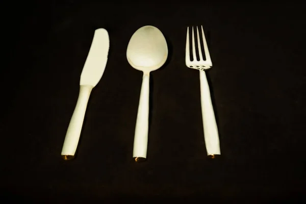 Fourchette, cuillère et couteau de table en bronze isolé sur bac noir — Photo