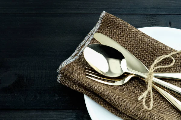 Una serie di posate in bronzo, cucchiaio, forchetta e coltello si dispongono su tovagliolo — Foto Stock