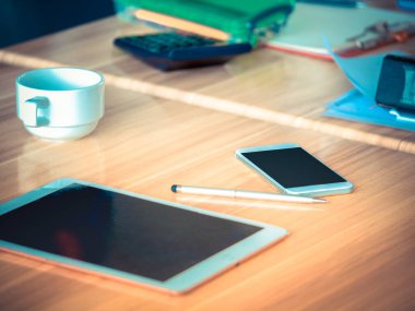 Bir tablet ve akıllı telefon çalışma masasında.