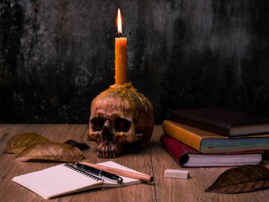 İnsan kafatası üzerinde mum ile bir sihirbaz çalışma masası, m kitapları