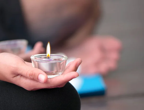 Рука молодой женщины, держащей чашку свечи в медитации pra — стоковое фото
