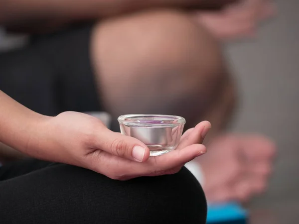 De hand van jonge vrouw houden kaars beker in de meditatie pra — Stockfoto