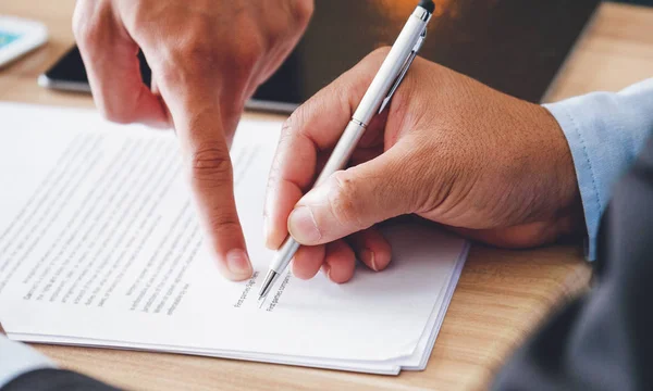 Primer plano de la mano del hombre de negocios que tiene documento de firma de pluma con un — Foto de Stock