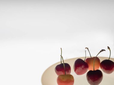 Parlak parlayan beyaz floo üzerinde beyaz plaka üzerinde taze kiraz