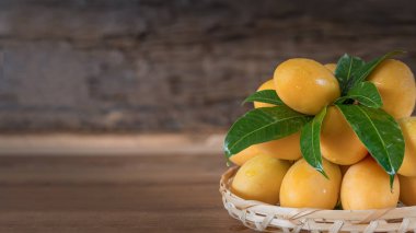 Bulanık ile ahşap masada bambu sepeti nde Tatlı Marian erik