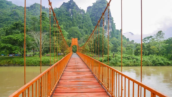 An orange bridge across Song river at Vang Vieng, Laos. Stock Photo