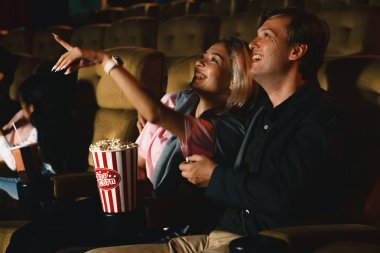 Gülen suratlı, beyaz bir çift filmdeki komik filmleri izliyor.