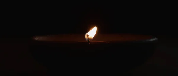 Зажигание свечи в Cray чашку на темном фоне — стоковое фото