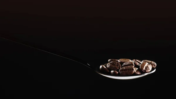 Kavrulmuş kahve çekirdeklerinin kaşık içinde izole edilmiş içecek arka planı. — Stok fotoğraf