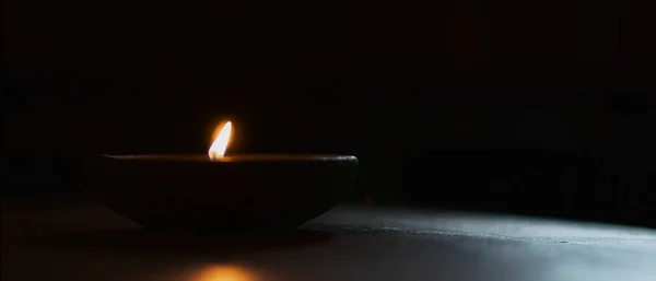 어두운 배경에 있는 크레이 컵에 있는 촛불 — 스톡 사진