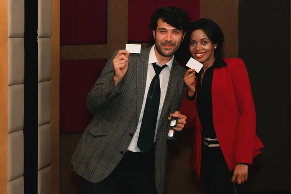 diversity couple happy showing movie ticket at theater entrance