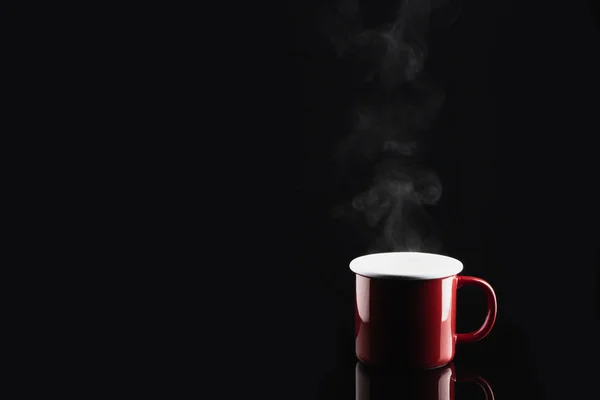 Steaming coffee or tea in red mug with reflection on dark backgr — Stock Photo, Image