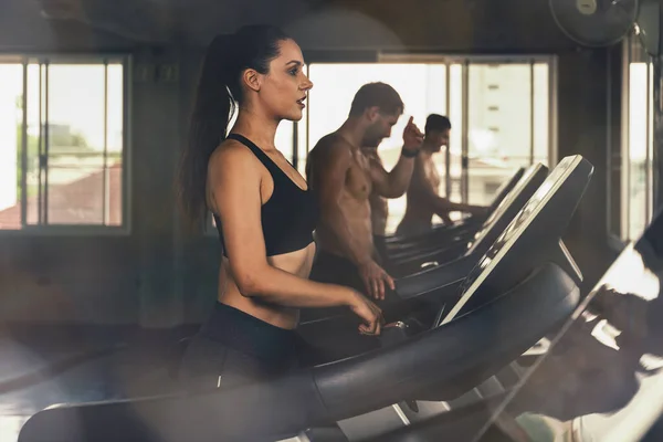 在健身馆和健身俱乐部参加跑步机跑步减肥运动的高加索女运动员 — 图库照片