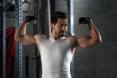 Kafkas atletizminin spor portresi güçlü vücut geliştirme pozu veren adam kaslarını koyu tonda gösteriyor.