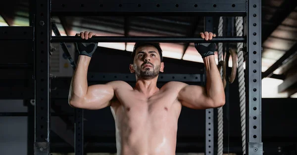 caucasian athletics man pull up exercise on high bar in gym and fitness club