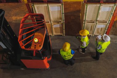 Lojistik depo işletmelerinin depolama deposunda takım çalışması yapan fabrika işçileri ve yöneticilerinin görüşü