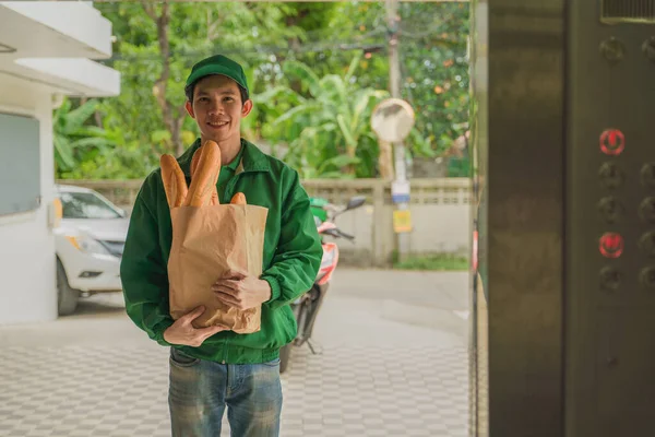 Asiático Entrega Hombre Verde Uniforme Pie Llevar Bolsa Comestibles Con — Foto de Stock