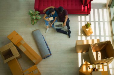 Dizüstü bilgisayarlı Asyalı çift online müşterilerden ürün siparişi alıyor. sme alışveriş çevrimiçi sahibi müşteriye gönderilecek ürünler hazırlıyor