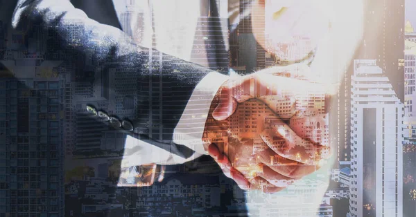都市を背景にしたビジネスマンの握手の多露出ビジネスの背景 — ストック写真