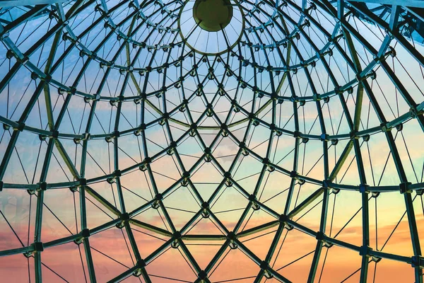 Modern and Contemporary of metal truss structure transparency glass dome roof of modern office building with sunset sky background