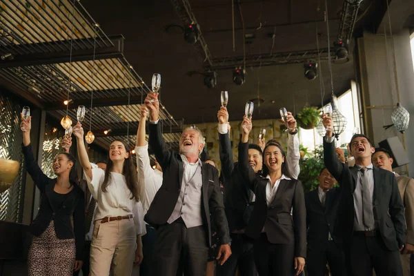 企業記念日などの特別なイベントで友情とチームワークを祝うために一緒にワインやシャンパンのビジネスパーティーの乾杯をしている企業のビジネスマン — ストック写真